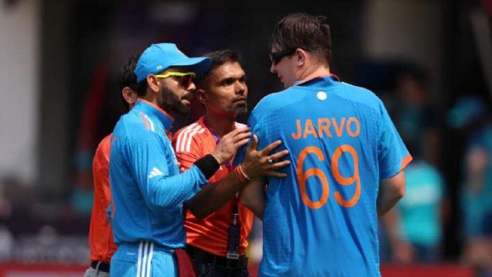 Virat Kohli accompanies an English pitch invader who makes an appearance during a World Cup game